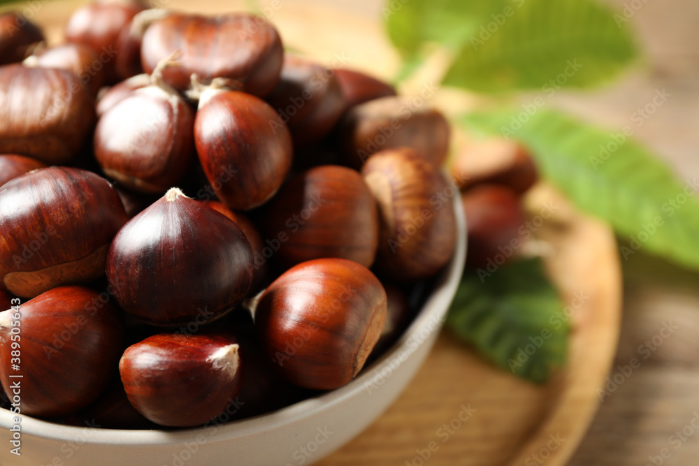 Fresh sweet edible chestnuts in bowl on table, closeup Fresh sweet edible chestnuts in bowl on table, closeup