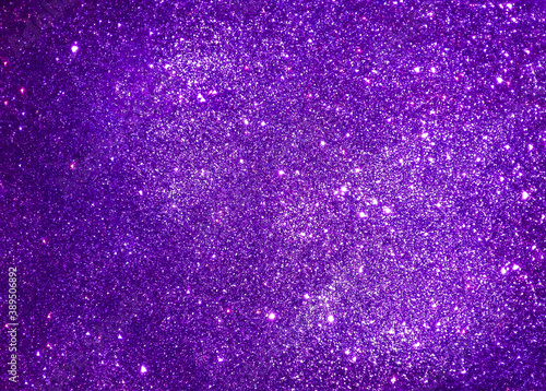 Violet abstract sparkle background reminding starry night sky. Purple glitter texture of decoration material. 