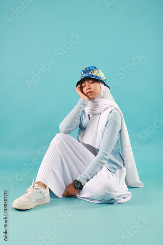 Fashion portrait of young beautiful asian muslim woman with wearing hijab on blue background