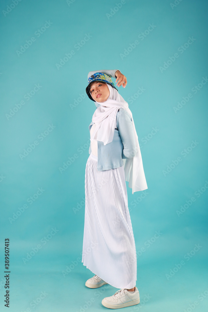 Fashion portrait of young beautiful asian muslim woman with wearing hijab on blue background Fashion portrait of young beautiful asian muslim woman with wearing hijab on blue background