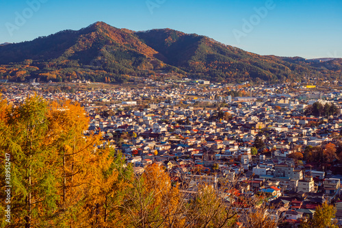 Japan city. City at foot of Kawaguchiko. Japanese province in autumn day. Fujiyoshida on a blue sky background. Mountains rise above Japanese province. Fujiyoshida Tourism. Holidays in Japan. photo