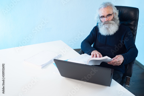 Adult man next to laptop. E...