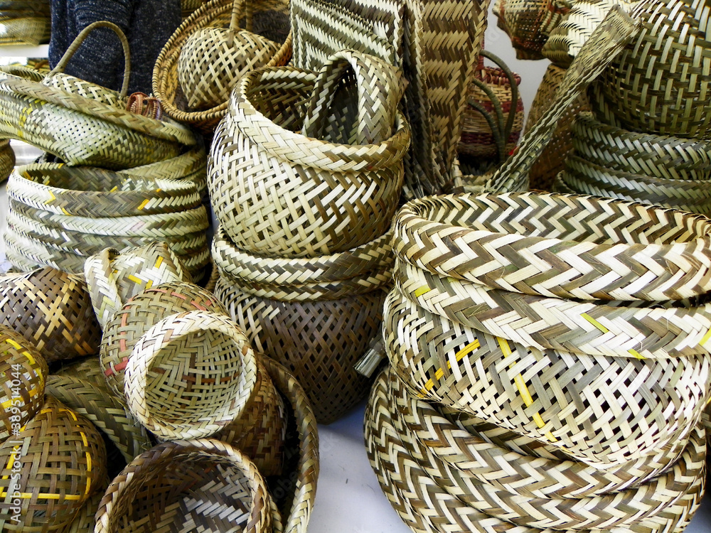 A pile of handmade natural traditional woven baskets and other objects from Esmeralda province made from paja toquilla straw at the outdoor market. Ecuador, South America