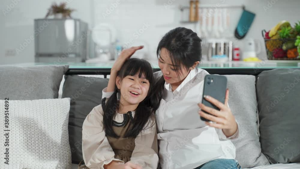 Asian young mother and daughter making video call with her husband. Asian young mother and daughter making video call with her husband.