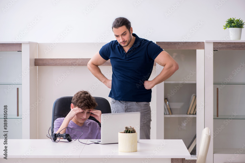 Young father and schoolboy playing computer games at home Young father and schoolboy playing computer games at home