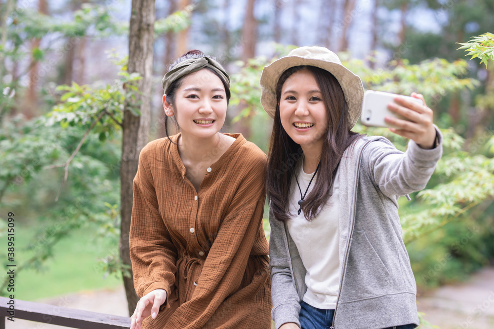 Fototapeta premium キャンプでスマホを見る女性 