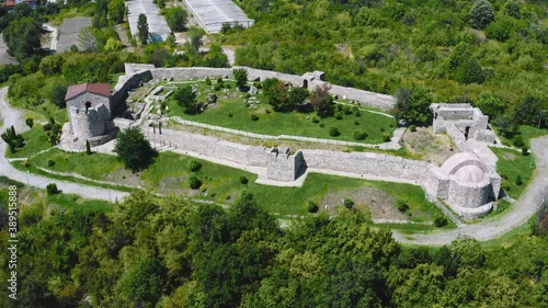 Flying sideways over Peristera fortress surrounded by green forest in Peshtera Bulgaria, photo