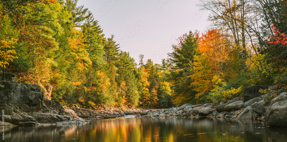 Long exposure photograph of water with a mirror like reflection of fall foliage colors in the Adirondacks, NY Long exposure photograph of water with a mirror like reflection of fall foliage colors in the Adirondacks, NY