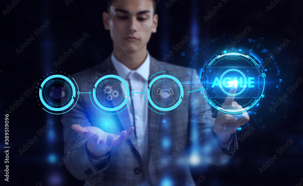 Business, Technology, Internet and network concept. Young businessman working on a virtual screen of the future and sees the inscription: Agile Business, Technology, Internet and network concept. Young businessman working on a virtual screen of the future and sees the inscription: Agile