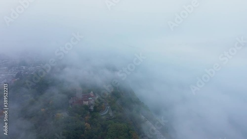 Aerial ascent into the fog with a hint of the Cloisters and the George Washington Bridge in Upper Manhattan New York City photo