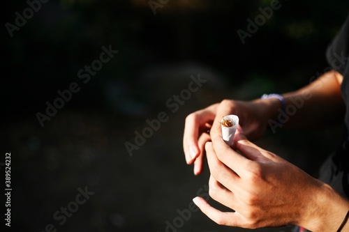 close up hands rolling up cigarette © ozzuboy