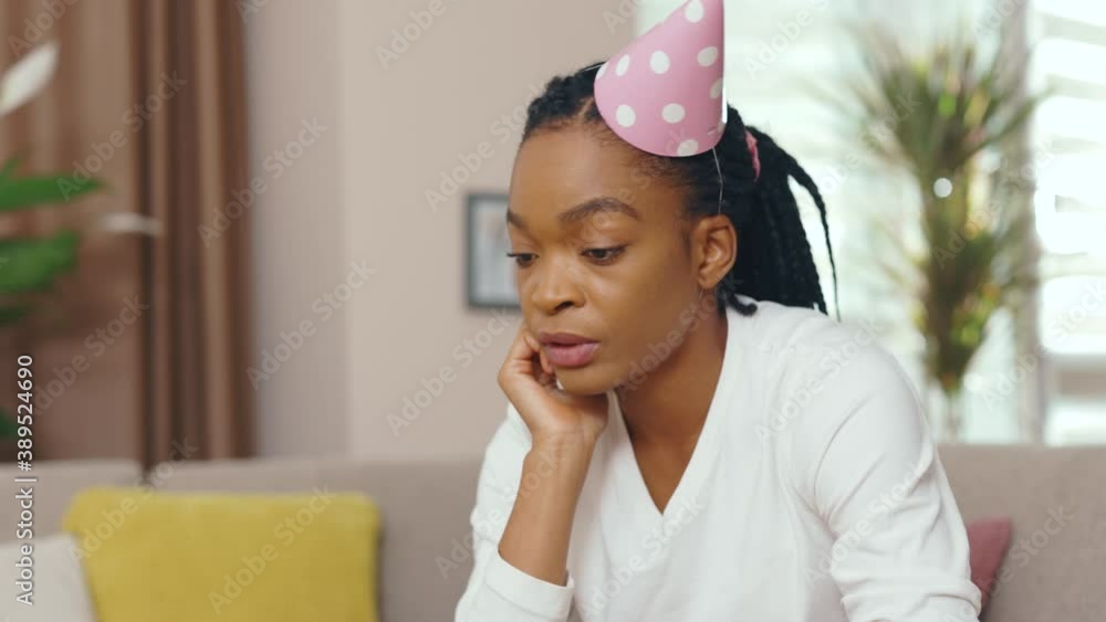 Close up face african american woman sitting on sofa staying at home alone for birthday having no messages on phone and laptop. Feel frustrating. Sad holidays. Isolation. Slow motion Close up face african american woman sitting on sofa staying at home alone for birthday having no messages on phone and laptop. Feel frustrating. Sad holidays. Isolation. Slow motion