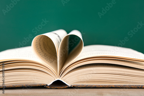 The pages of a book in front of the blackboard are folded into hearts