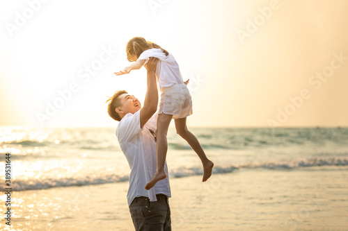 Happy Asian Family father carrying little cute daughter with smiling face on the beach in summer sunset. Dad and child girl enjoy and having fun together in outdoor lifestyle holiday vacation travel. © CandyRetriever 