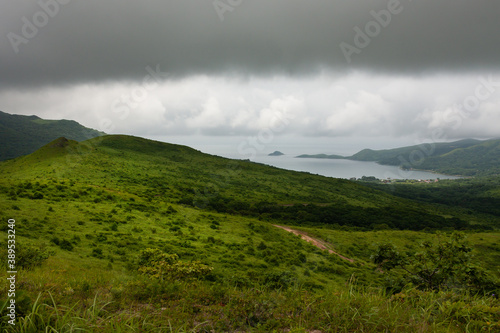 Bay of the sea from the top of the hill of the mountainous coast, summer landscape and seascape in cloudy cloudy weather.
