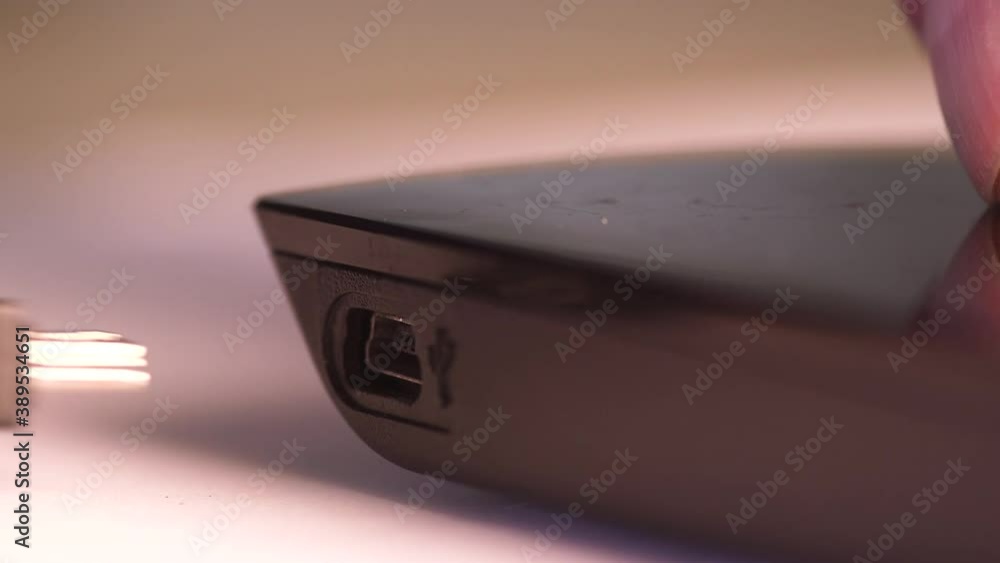 Close up of a man's hand hand plugging in external USB hard drive Close up of a man's hand hand plugging in external USB hard drive