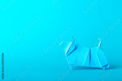 Origami bull as symbol of year 2021 on color background © Pixel-Shot