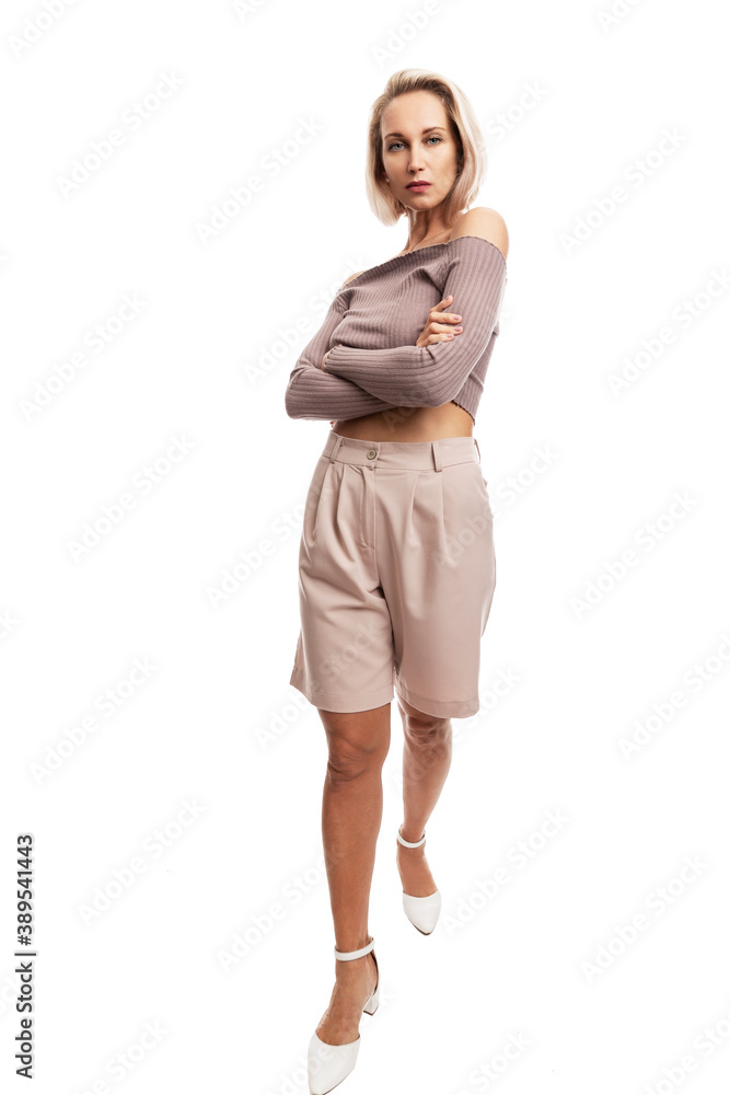 Fototapeta premium Serious young blond woman in pink suit. Full height. Isolated on white background. Vertical.