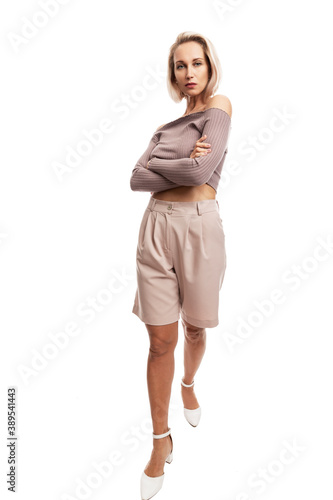 Serious young blond woman in pink suit. Full height. Isolated on white background. Vertical.