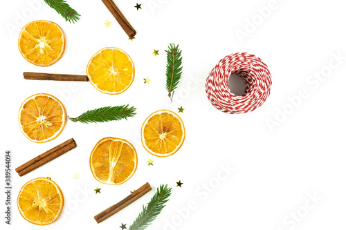 Christmas composition with dried oranges  cinnamon  fur tree branches and packing string on white background. Christmas decor for home. Flat lay with copy space