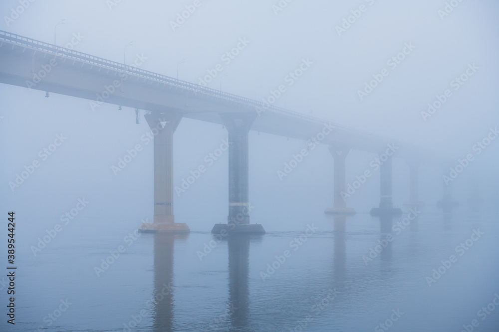 Bridge over the river in heavy fog