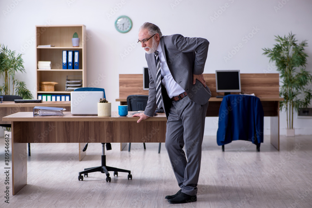 Old male employee suffering from radiculitis at workplace Old male employee suffering from radiculitis at workplace