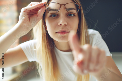 Tableau sur toile A woman has vision problems, squints when trying to see something, takes off her glasses, is isolated