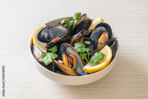 Mussels with herbs in a bowl with lemon