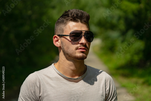 Portrait of stylish handsome young man. Fashion guy in sunglasses.
