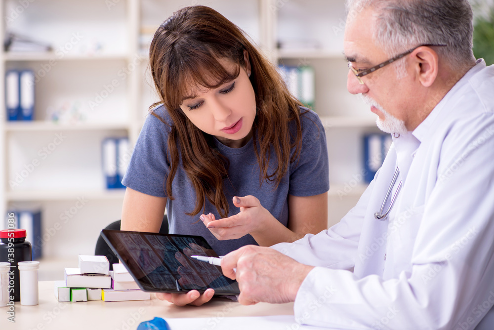 Fototapeta premium Young woman visiting old doctor radiologist