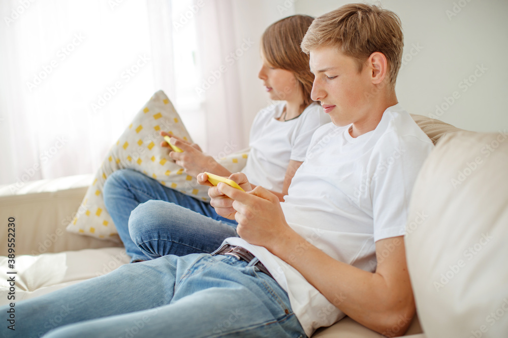leisure, technology, technology, family and people concept - happy boys and boy with smartphones sending text messages or playing games at home. High quality photo.