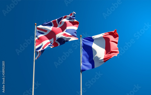 Beautiful national state flags of France and UK together at the sky background. 3D artwork concept.