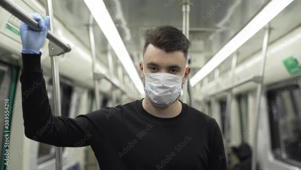 Young Man In Medical Mask Travelling In Trolleybus While Look In The