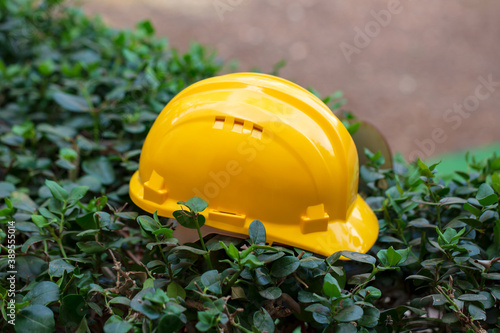 Yellow safety helmet on nature background. Industrial workers or construction site safety equipment concept. Plastic safety helmet, hard hat, side view. Construction, Industry and repairing concept.