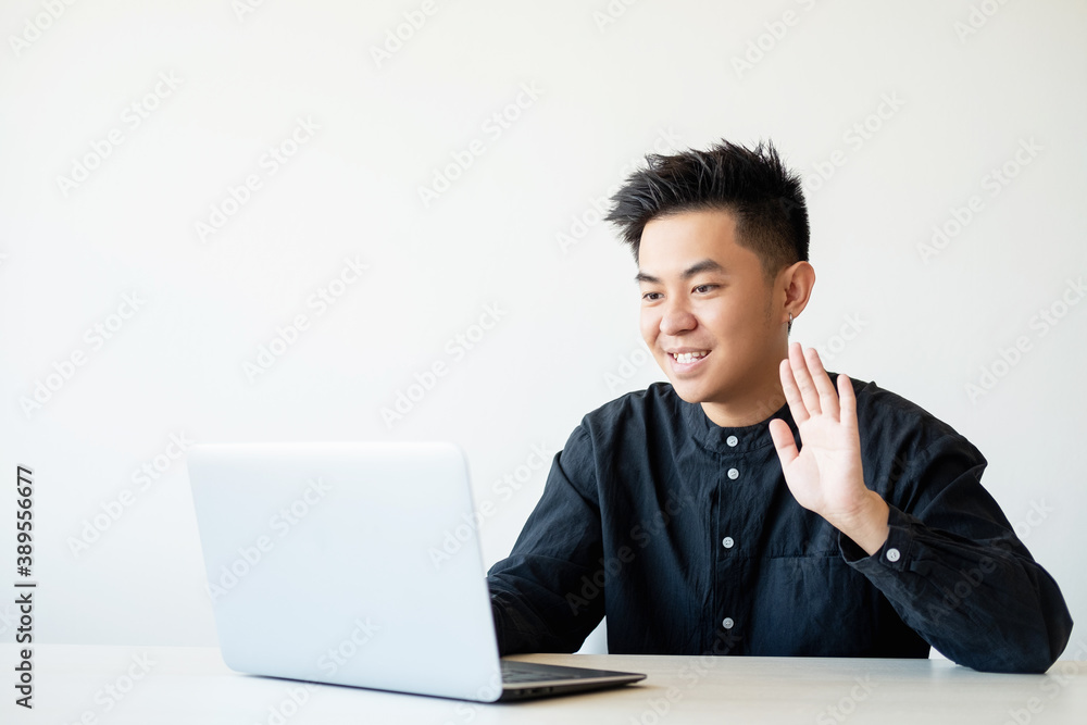 Online interview. Virtual meeting. Business webinar. Cheerful asian guy greeting team on laptop camera smiling isolated on white copy space background. Online interview. Virtual meeting. Business webinar. Cheerful asian guy greeting team on laptop camera smiling isolated on white copy space background.