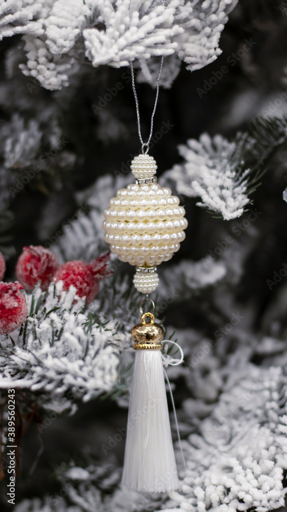 Fototapeta premium Christmas ball snow-covered fir tree, close-up, blurred bokeh background. Christmas background for a postcard. Decoration for a Christmas tree, spruce branches, New Year's toys.