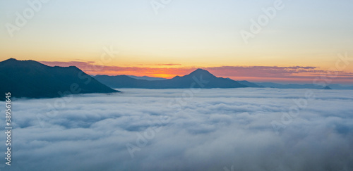 beautiful sunrise over mountain with fog in the morning