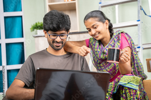 Quadro em tela Couple at Newly bought apartment or house searching or planning for home improvement products on laptop while sitting together at unfurnished room