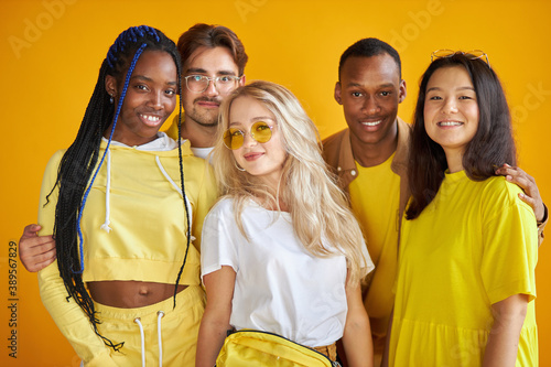 diversity, race, ethnicity and people concept. international group of happy friendly smiling men and women isolated on yellow background, studio shoot photo