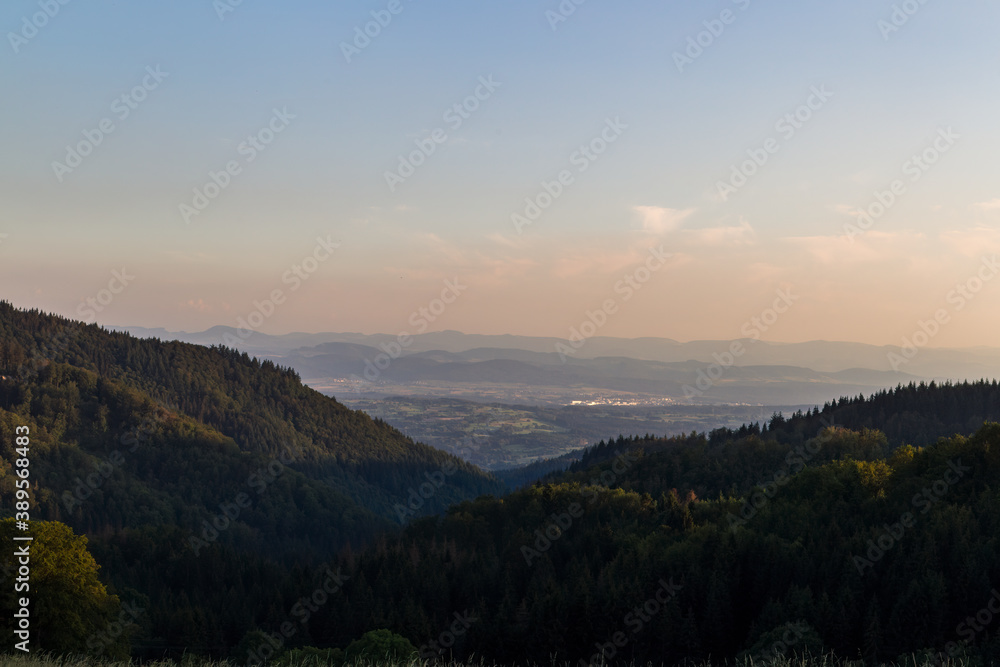 Fototapeta premium Panorama at sunset from the mountains of the Black Forest near Gersbach over the Wehratal and the city of Wehr towards the Swiss Alps