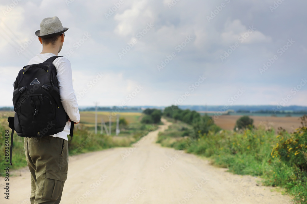 A man walks along a country road. Hitchhiker around the country. A man stops a passing car on the road. A man walks along a country road. Hitchhiker around the country. A man stops a passing car on the road.