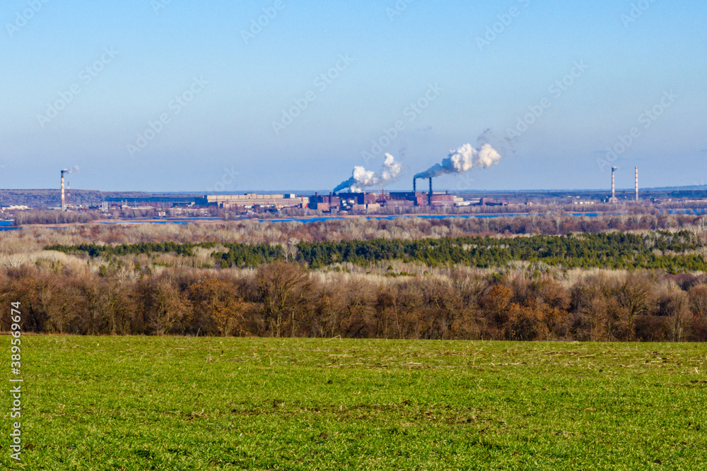 View on smoke pipes of the factory and agricultural field