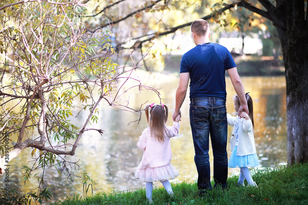 Fototapeta premium Leaf fall in the park. Children for a walk in the autumn park. Family. Fall. Happiness.