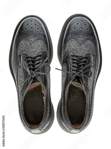 Beautiful pair of demi-season men's leather shoes with perforations and inserts of gray monochrome wool, isolated on a white background with shadow. Top view.