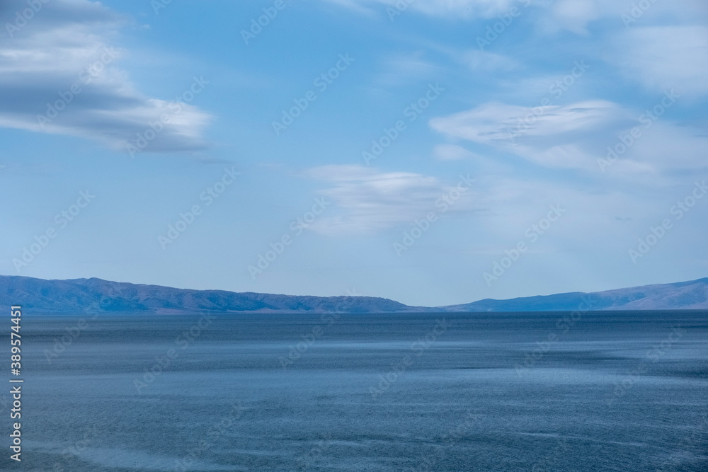 View on lake with mountains and cloudy sky  background. Mountain lake in autumn. Markakol lake in Kazakhstan.