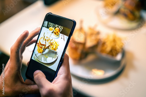 Food photography blogger influencer taking picture with her smartphone. Close up on the cell phone screen.