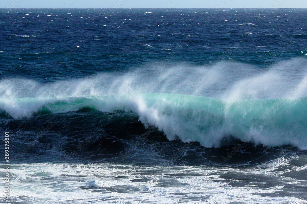 Big waves on indian ocean at the shore of Reunion island just moments before hitting the water on a very windy and sunny day.