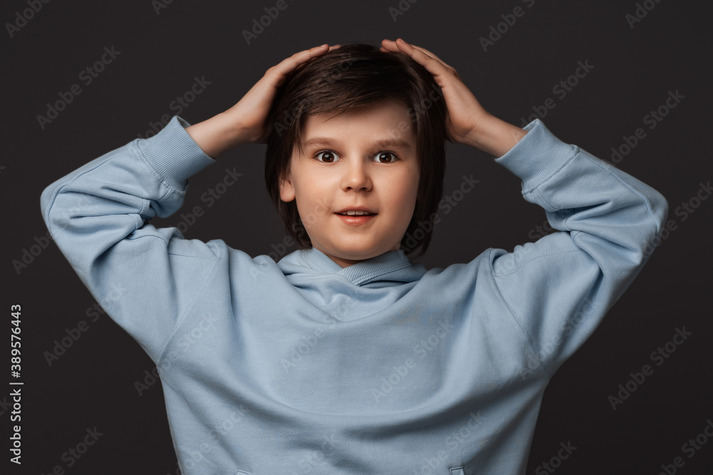 Image of shocked boy expressing surprise on camera. Studio shot, gray background. Facial expression concept Image of shocked boy expressing surprise on camera. Studio shot, gray background. Facial expression concept