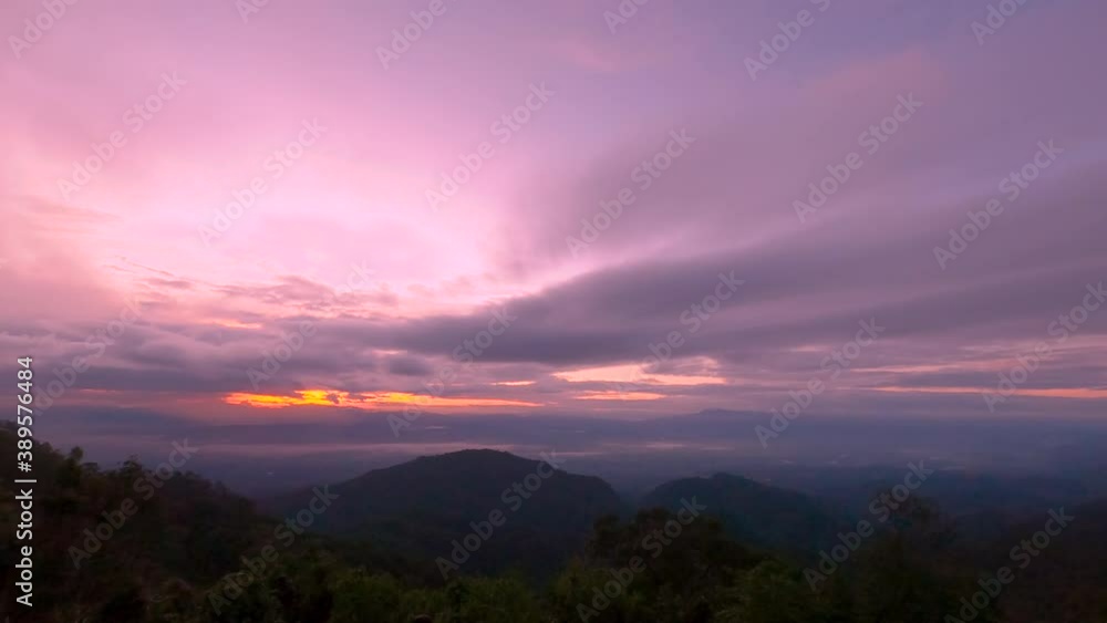 The time lapse of the beautiful sky with golden light shines through the clouds at sunrise in the morning on the mountain peak. The time lapse of the beautiful sky with golden light shines through the clouds at sunrise in the morning on the mountain peak.