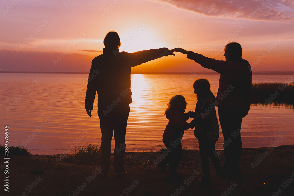 happy family with kids at sunset coast in winter